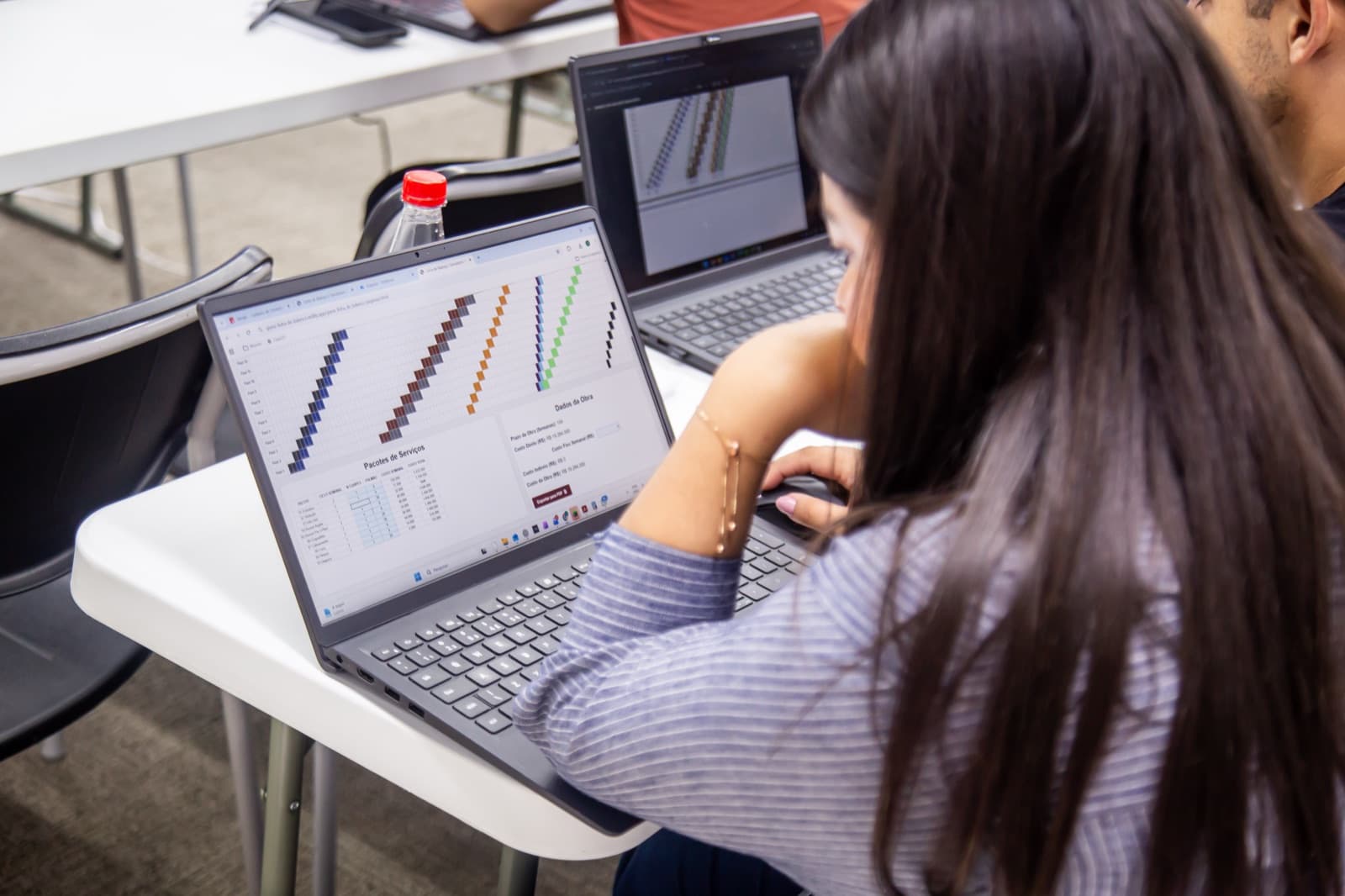 Participante trabalhando no notebook durante oficina prática em edição anterior